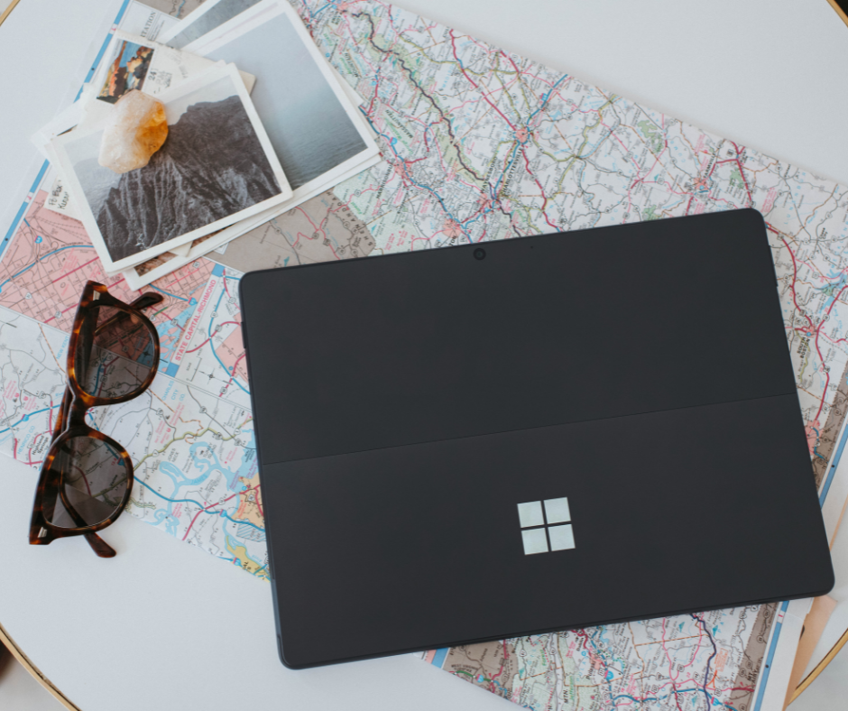 microsoft-surface-flat-on-top-of-map-and-sunglasses-and-polaroid-photos